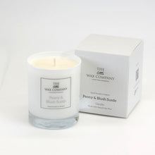 A white candle with a label that reads 'Peony & Blush Suede' alongside a white candle box, both with the brand 'THE LITTLE WAX COMPANY' visible.