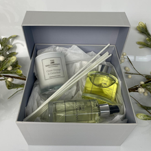 Gift set with candle, diffuser, and perfume bottle from The Wax Company on a white background.