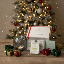 Wax melt gift set with decorative candles and small presents in front of a Christmas tree.