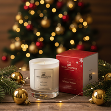 Candle and packaging from The Wax Company with a Christmas tree in the background